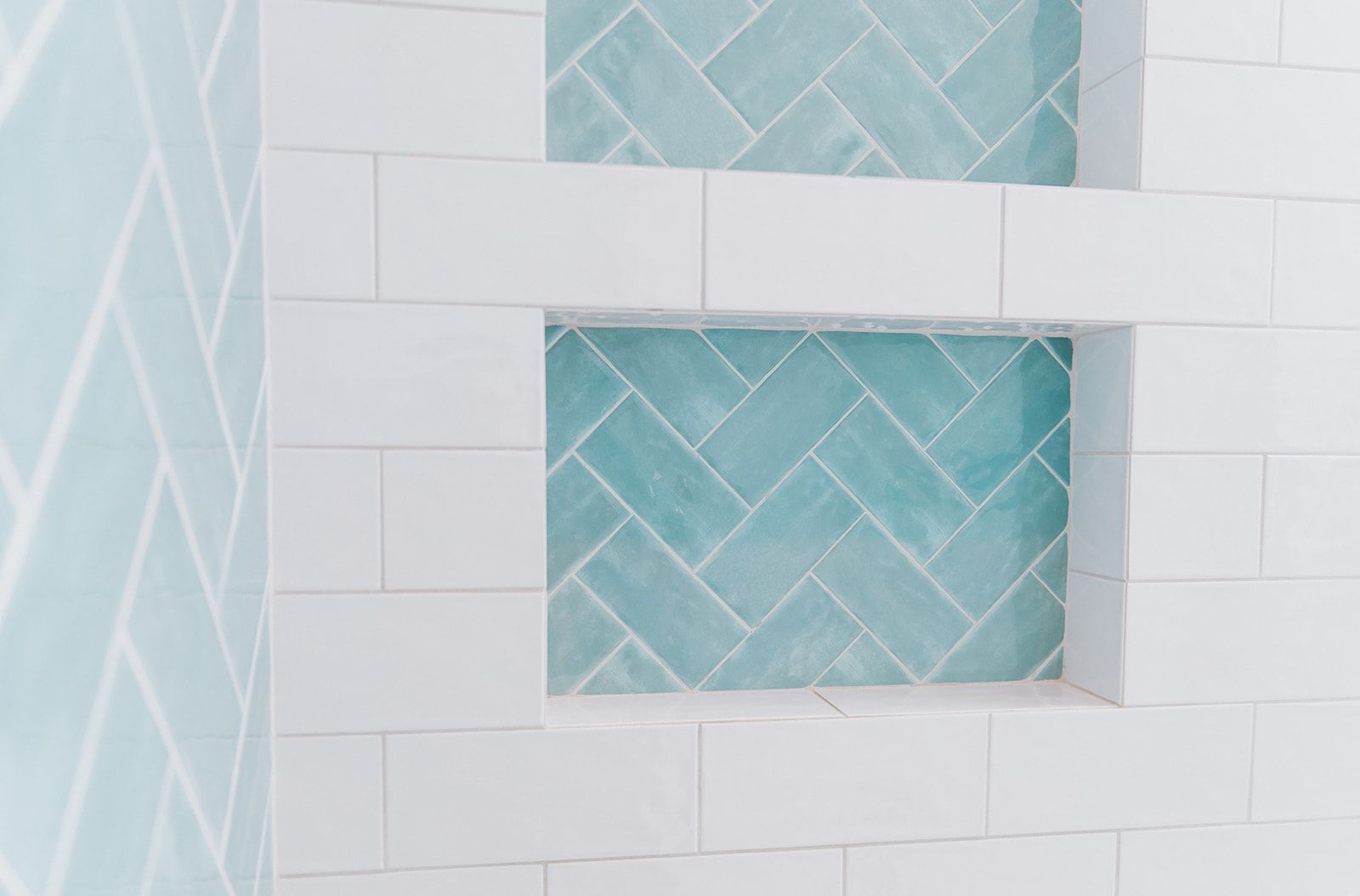 A bathroom with white tiles and blue tiles in a herringbone pattern