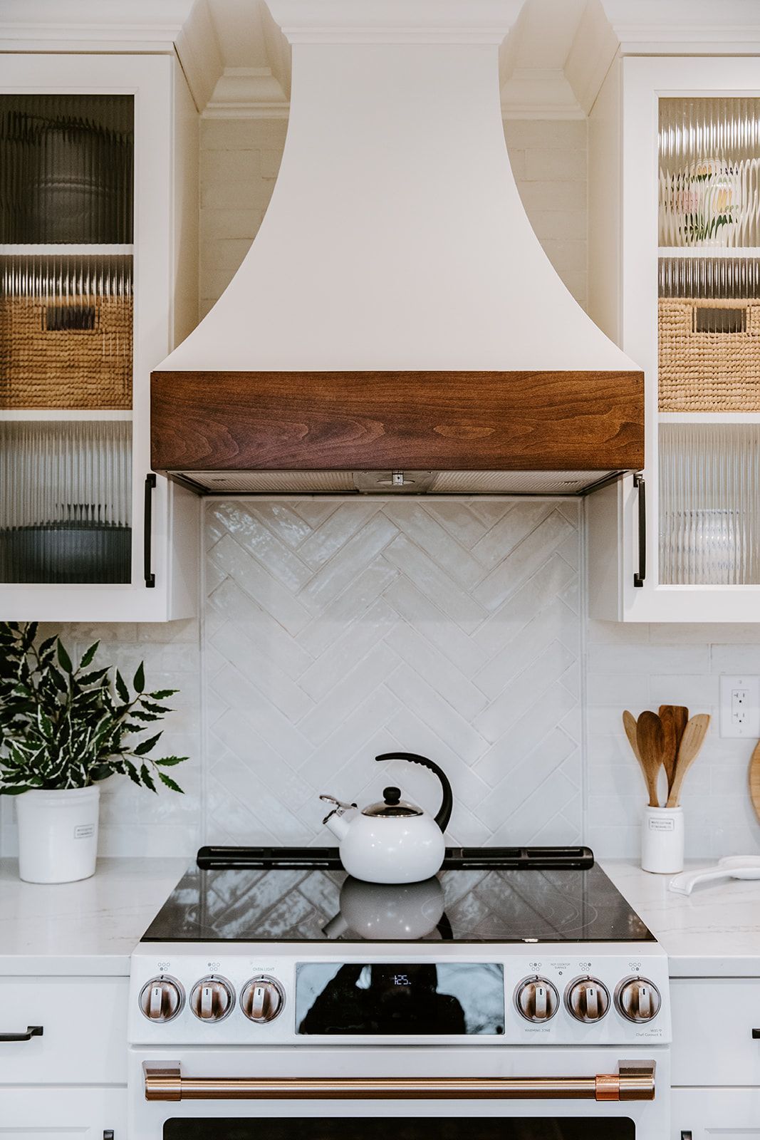 A kitchen with a stove and a kettle on it
