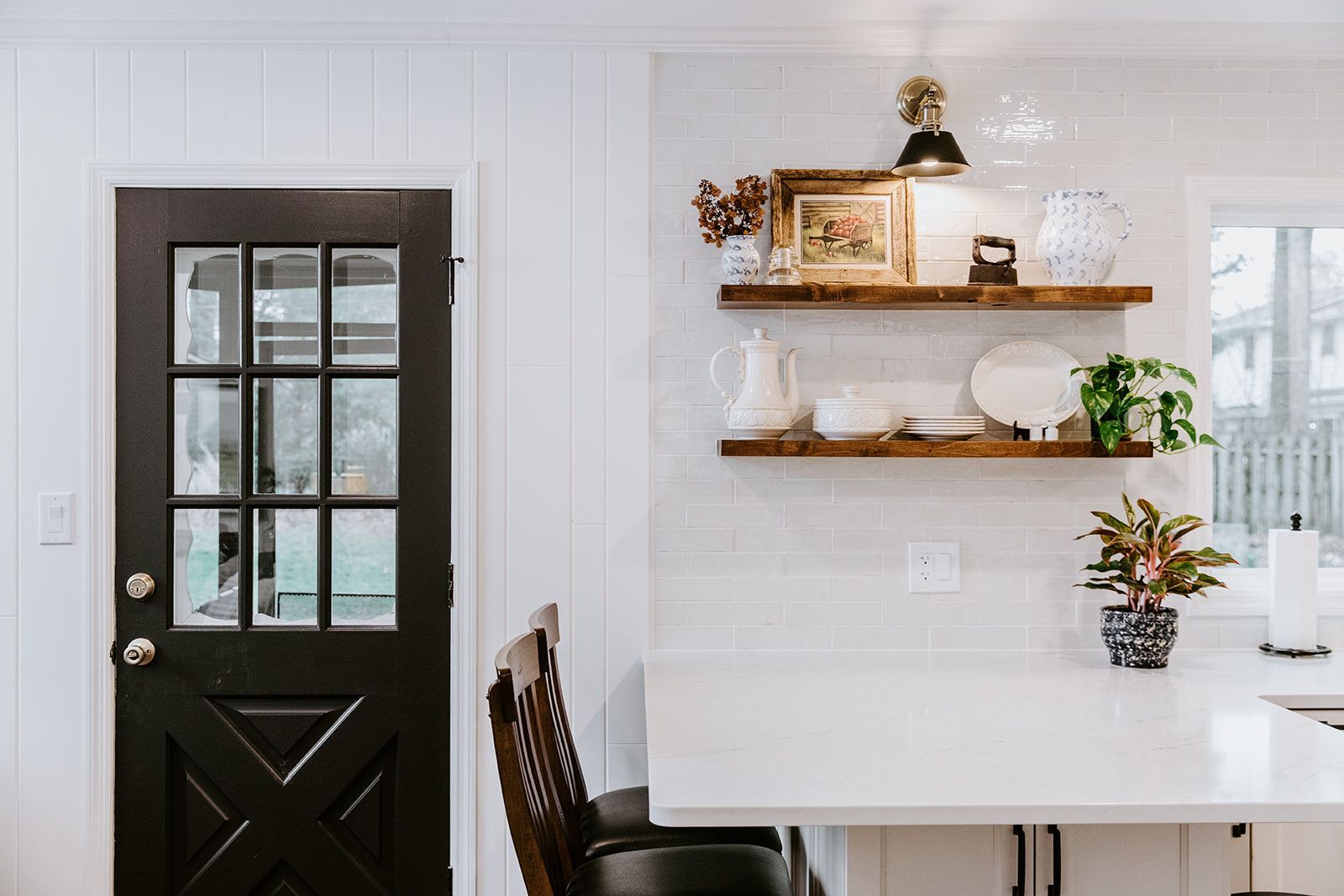 A kitchen with a black door and a white counter top