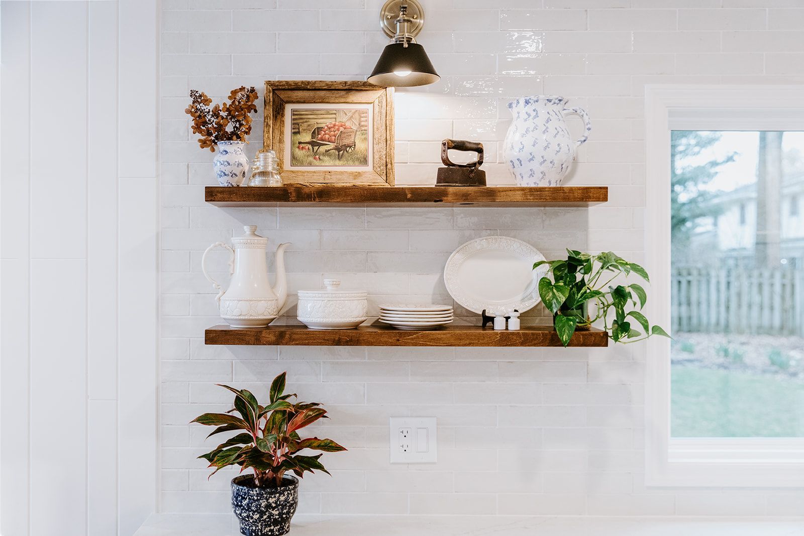 A kitchen with wooden shelves filled with plates