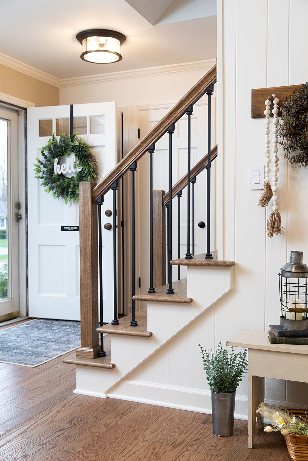 A hallway with stairs and a wreath on the door