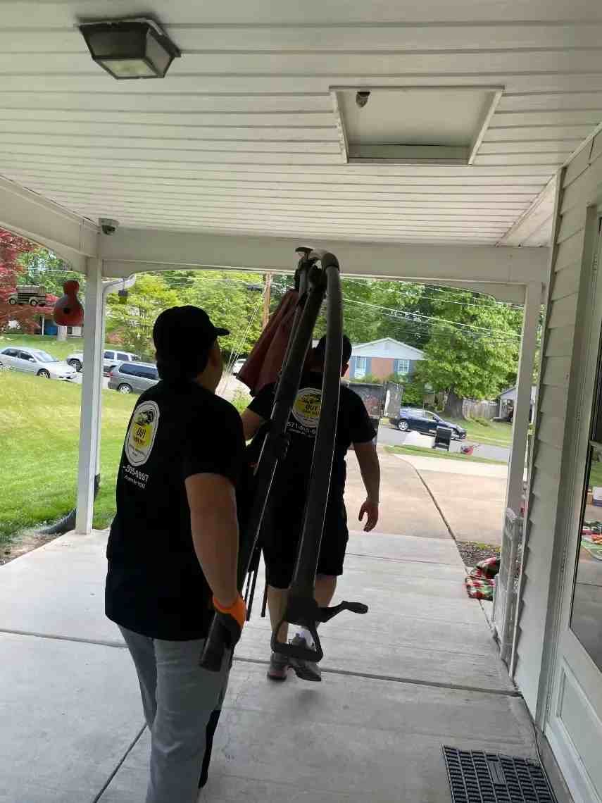 Men are carrying a large object on a porch