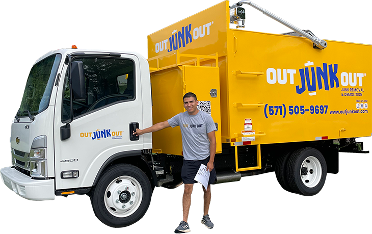 a man stands in front of a yellow out junk out truck