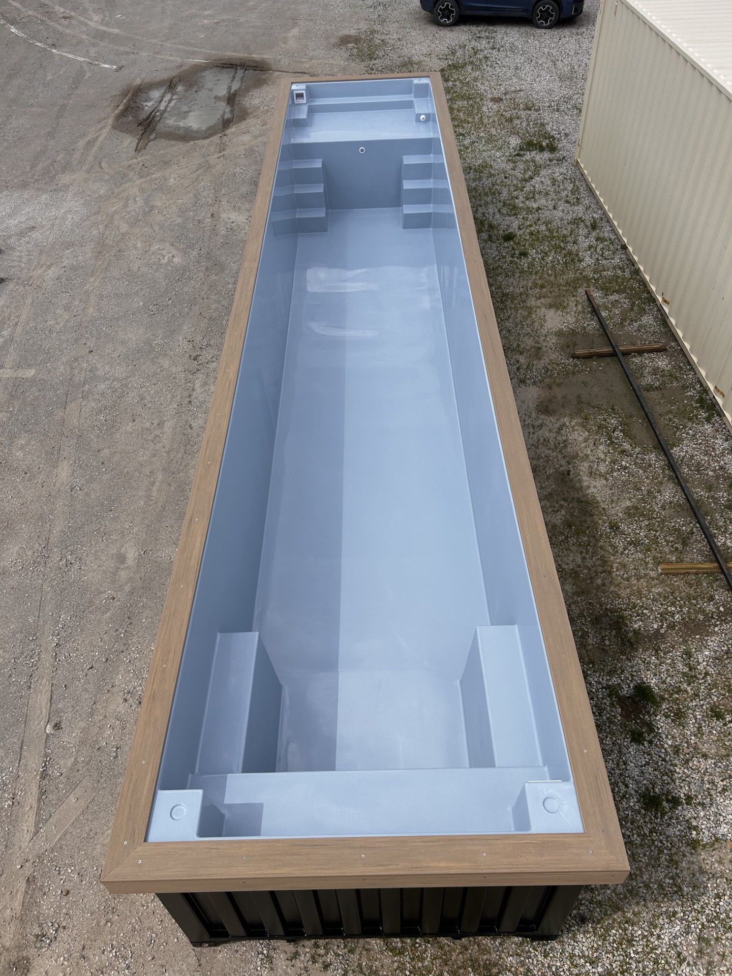 A large black swimming pool with stairs in a building