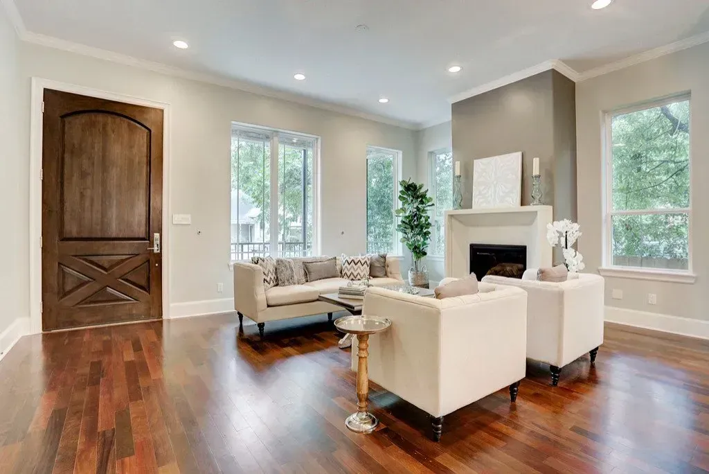 Living room with hardwood floors, a fireplace, and beige furniture.