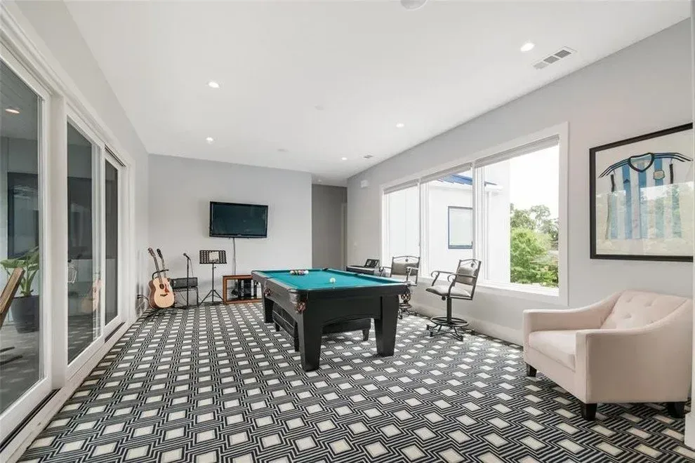 Pool room with a pool table, guitars, TV, and large windows.