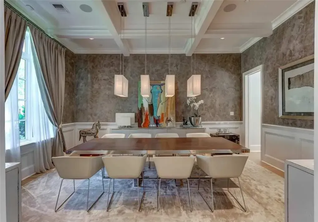 Elegant dining room with large wooden table, modern chairs, and rectangular pendant lights.