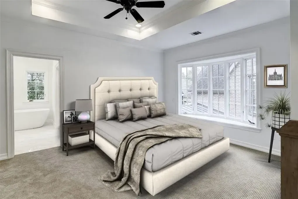 Bedroom with a bed, nightstand, and window with a view. Light gray walls, tan bed, and a neutral palette.
