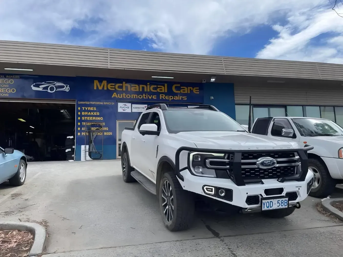 White pickup truck with a black bumper parked in front of an automotive repair shop. — Mechanical Care in Belconnen, ACT