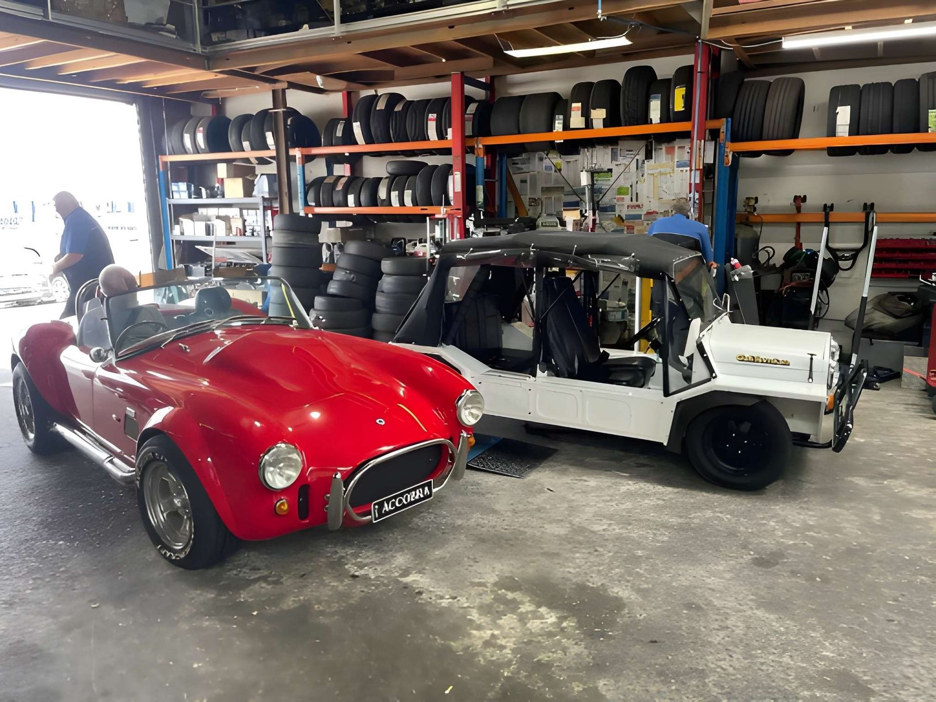 Red Sports Car and White Convertible Parked in a Garage With Tires and Equipment — Mechanical Care in Belconnen, ACT