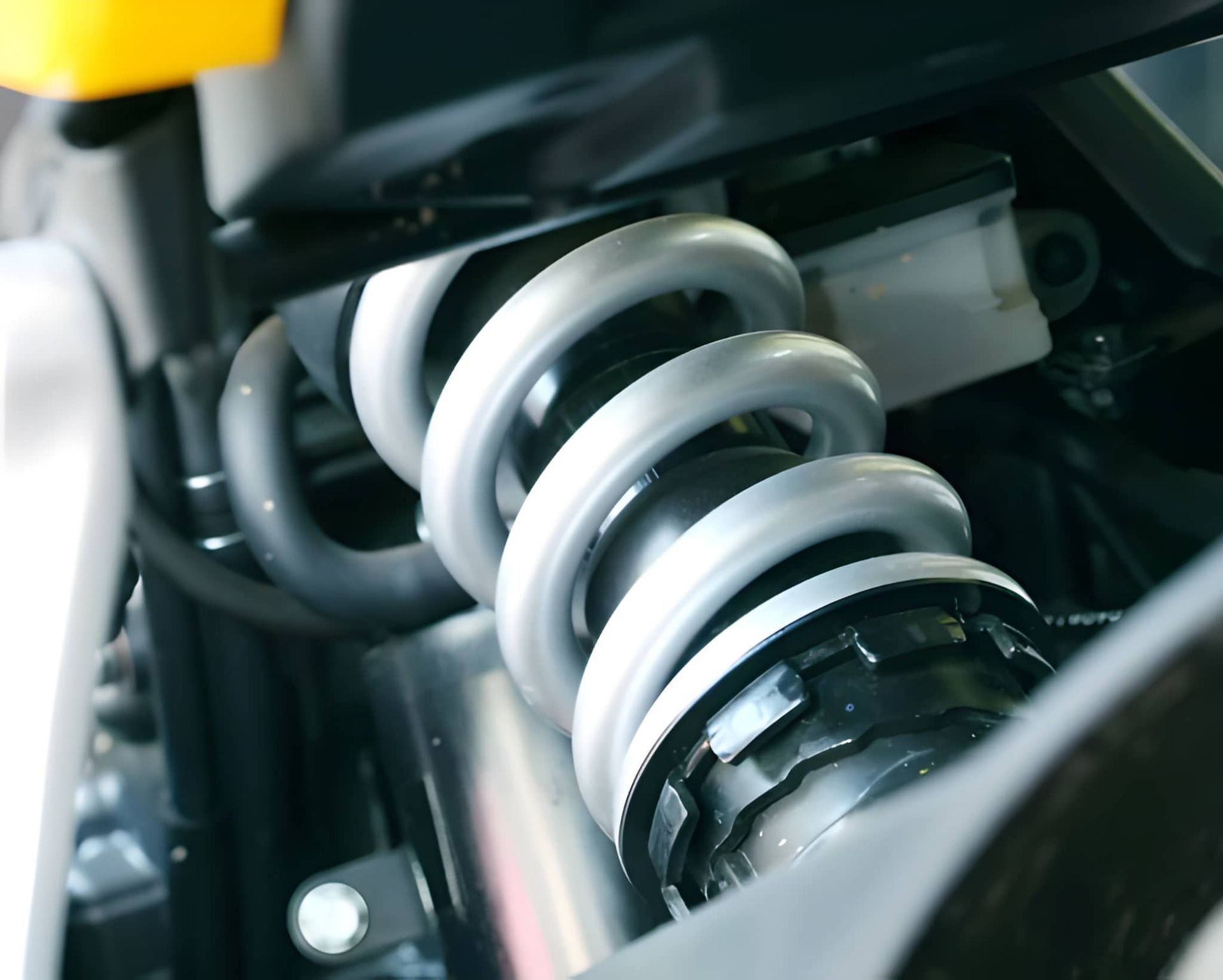 Close-Up of a Motorcycle Rear Suspension With a Silver Coil Spring — Mechanical Care in Belconnen, ACT