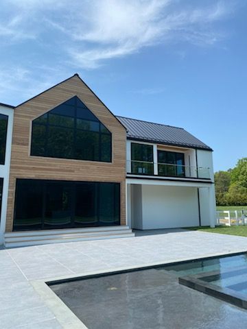 A large house with a swimming pool in front of it.