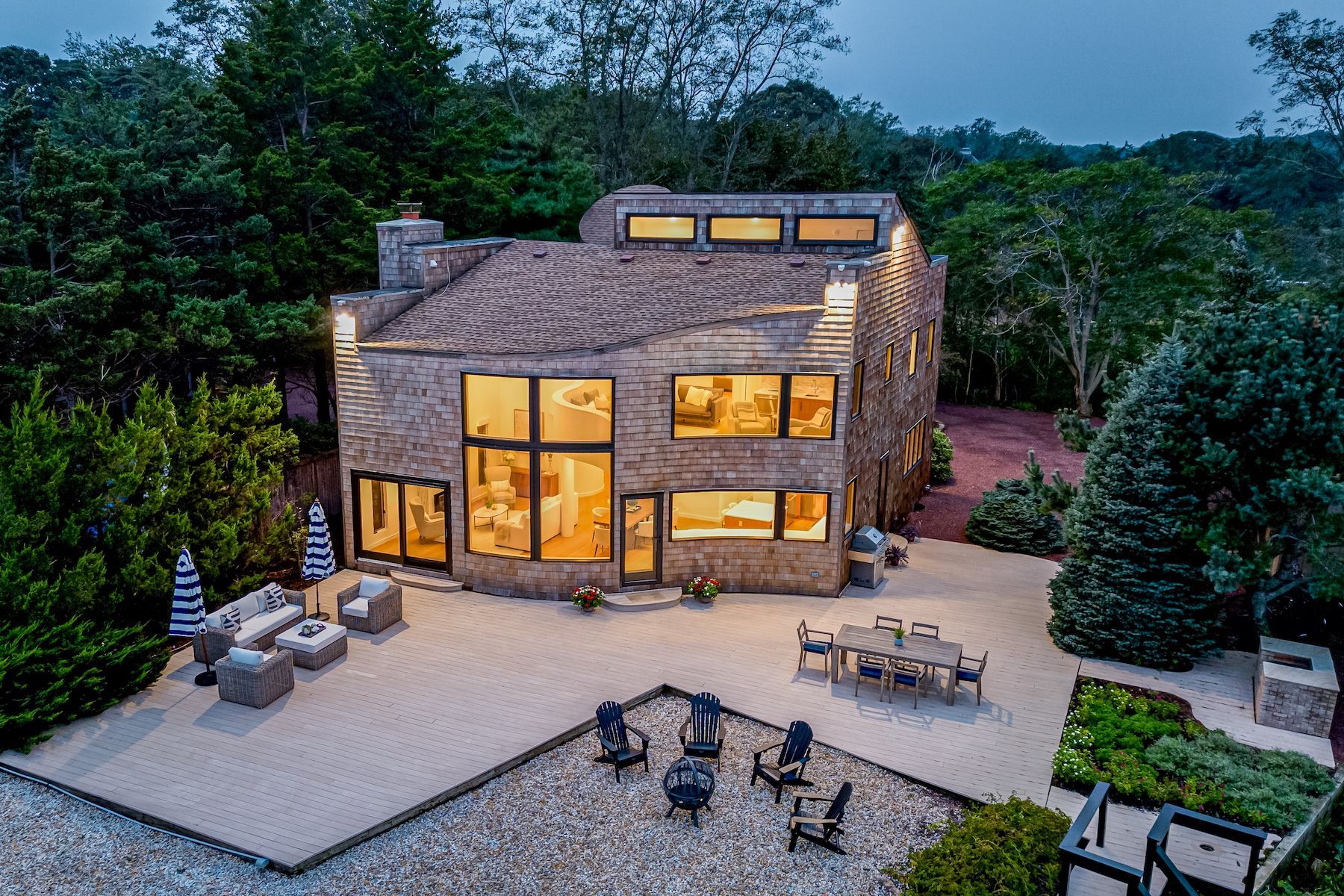 An aerial view of a large house with a patio and chairs in front of it.