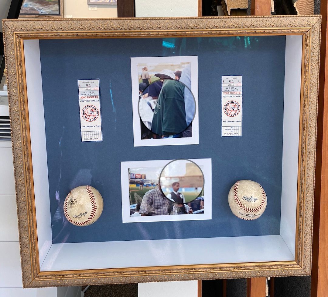 A framed picture of two baseballs and a picture of a man