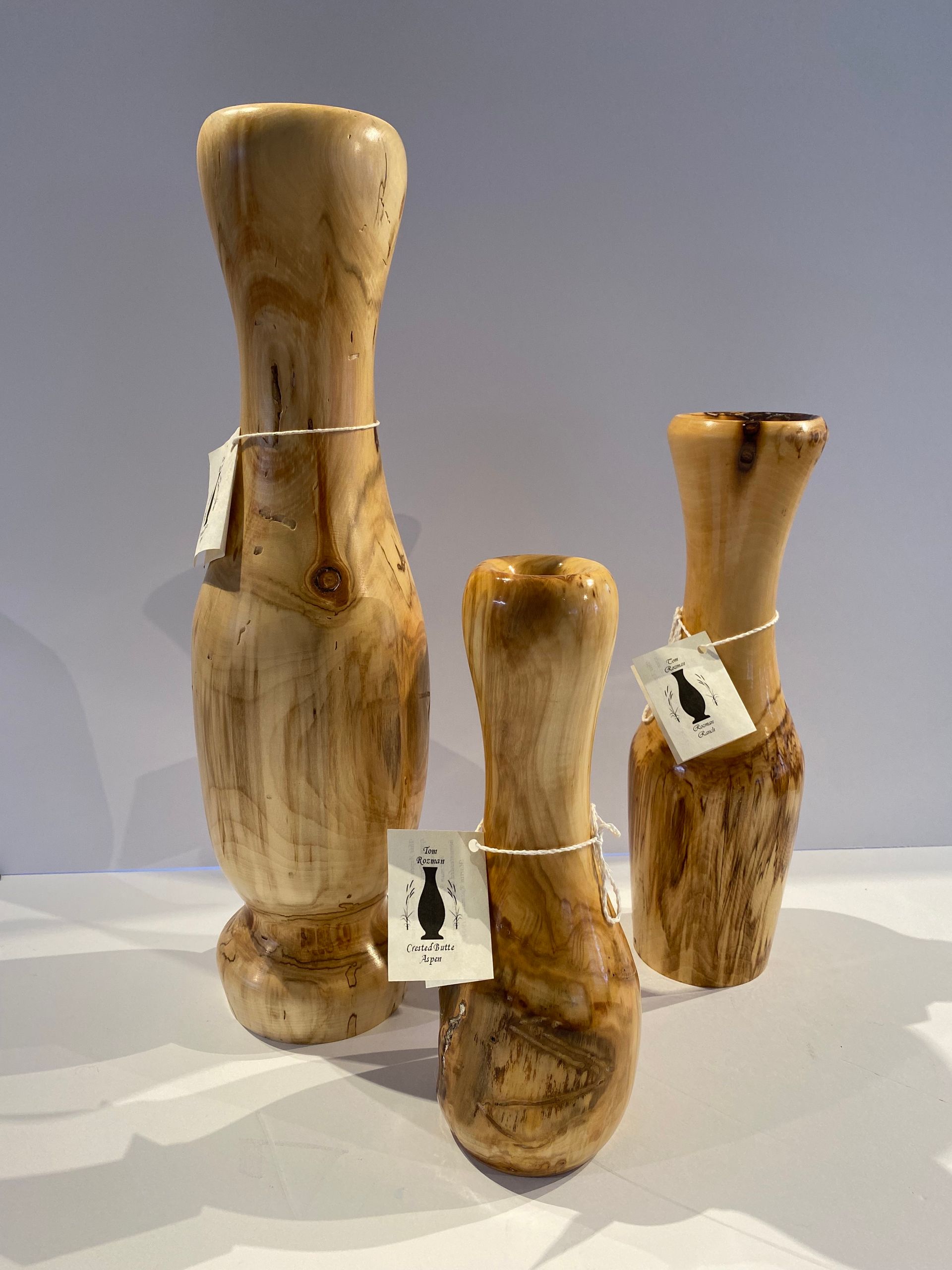 Three wooden vases are sitting next to each other on a table.