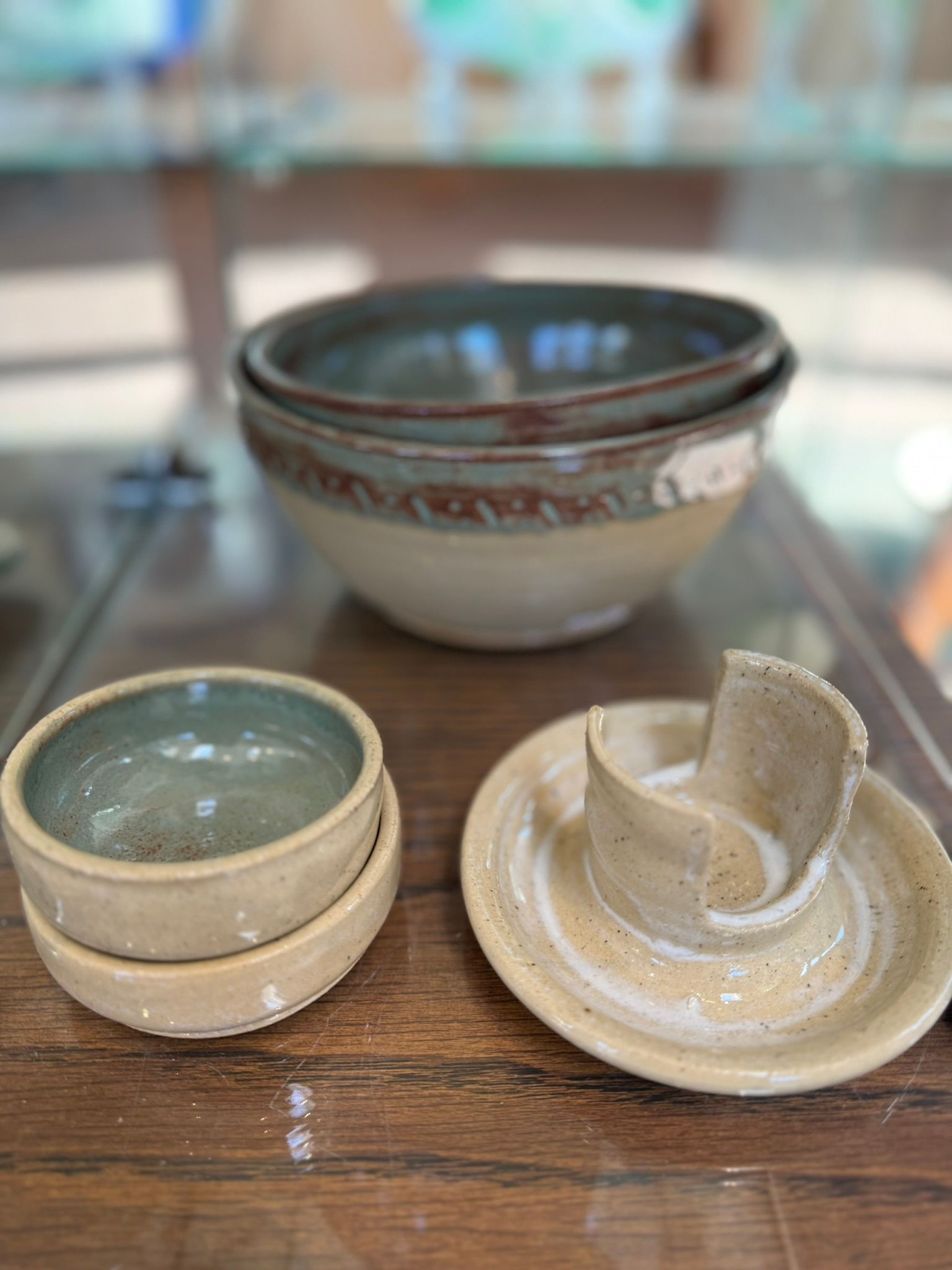 A stack of bowls and plates are sitting on a wooden table.