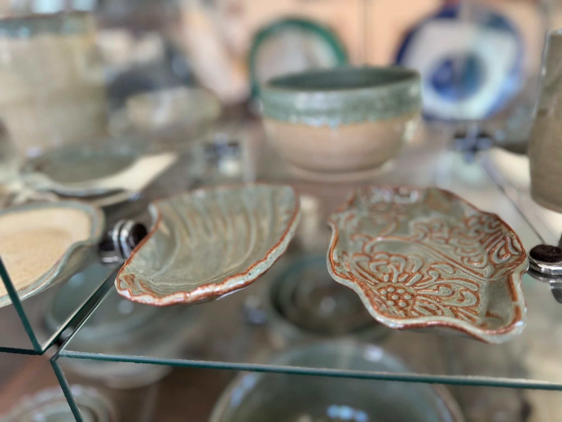 A glass display case filled with ceramic bowls and plates.