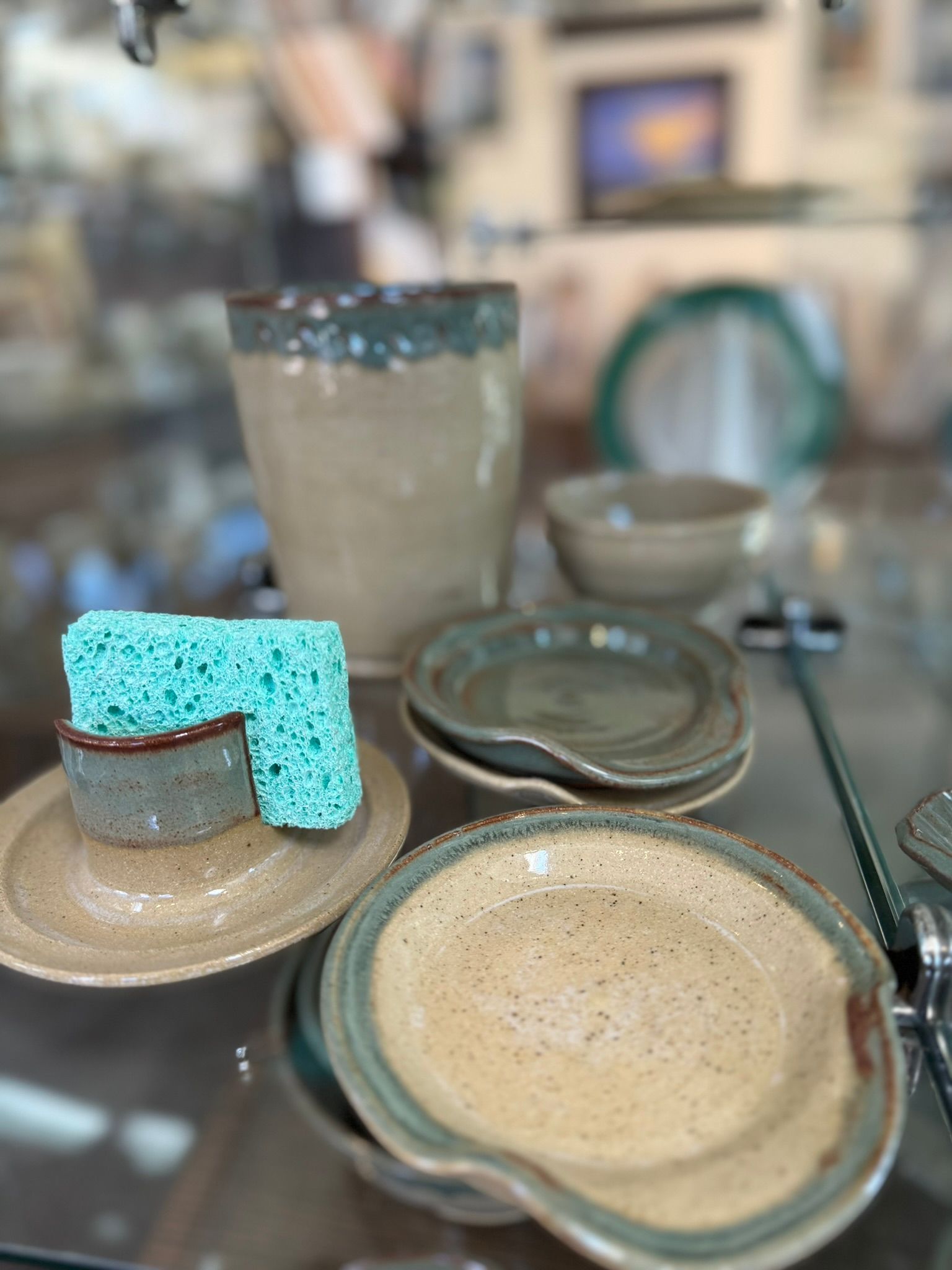 A table topped with plates , bowls , and a sponge.