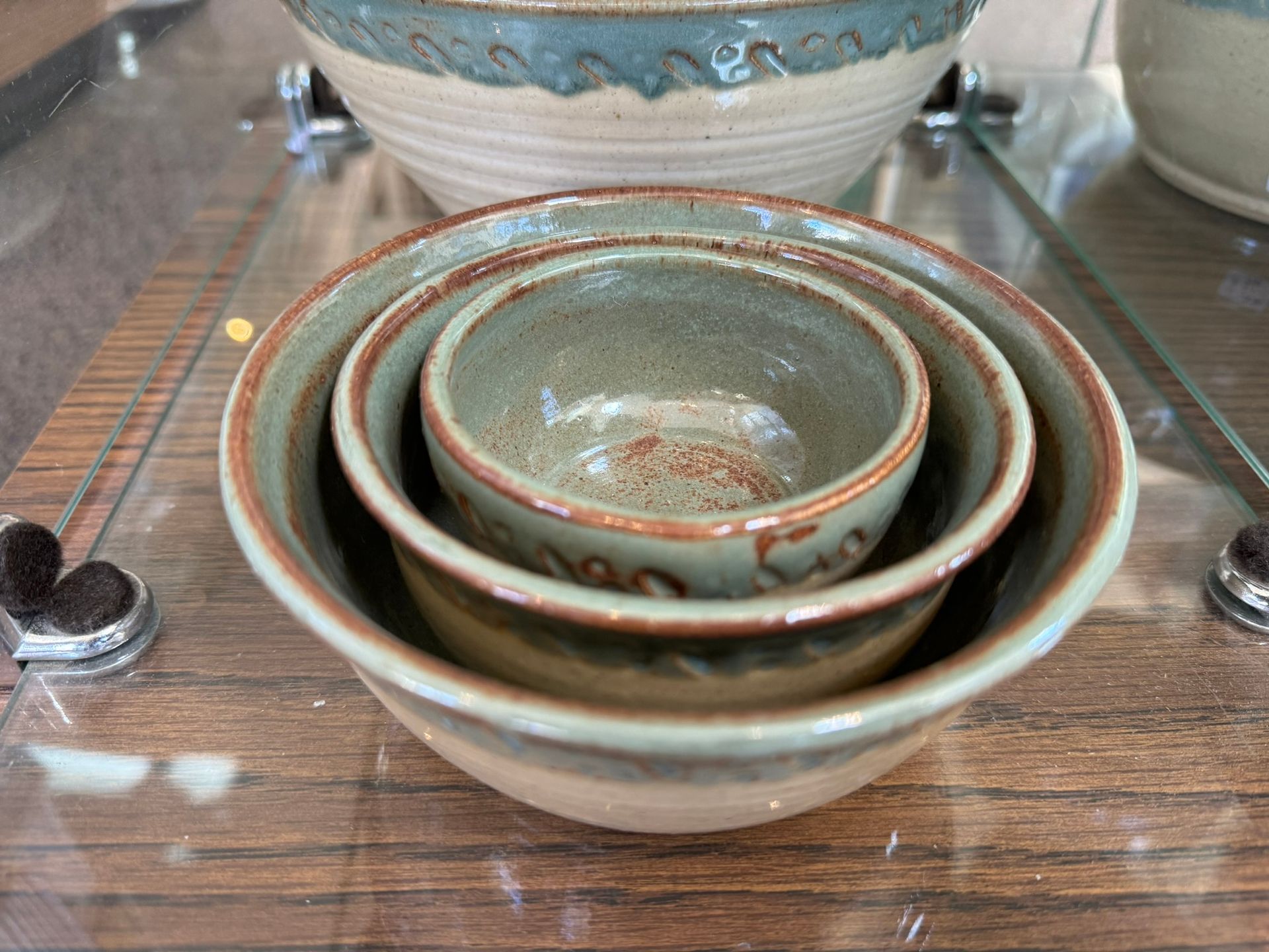 Three bowls are stacked on top of each other on a glass table.