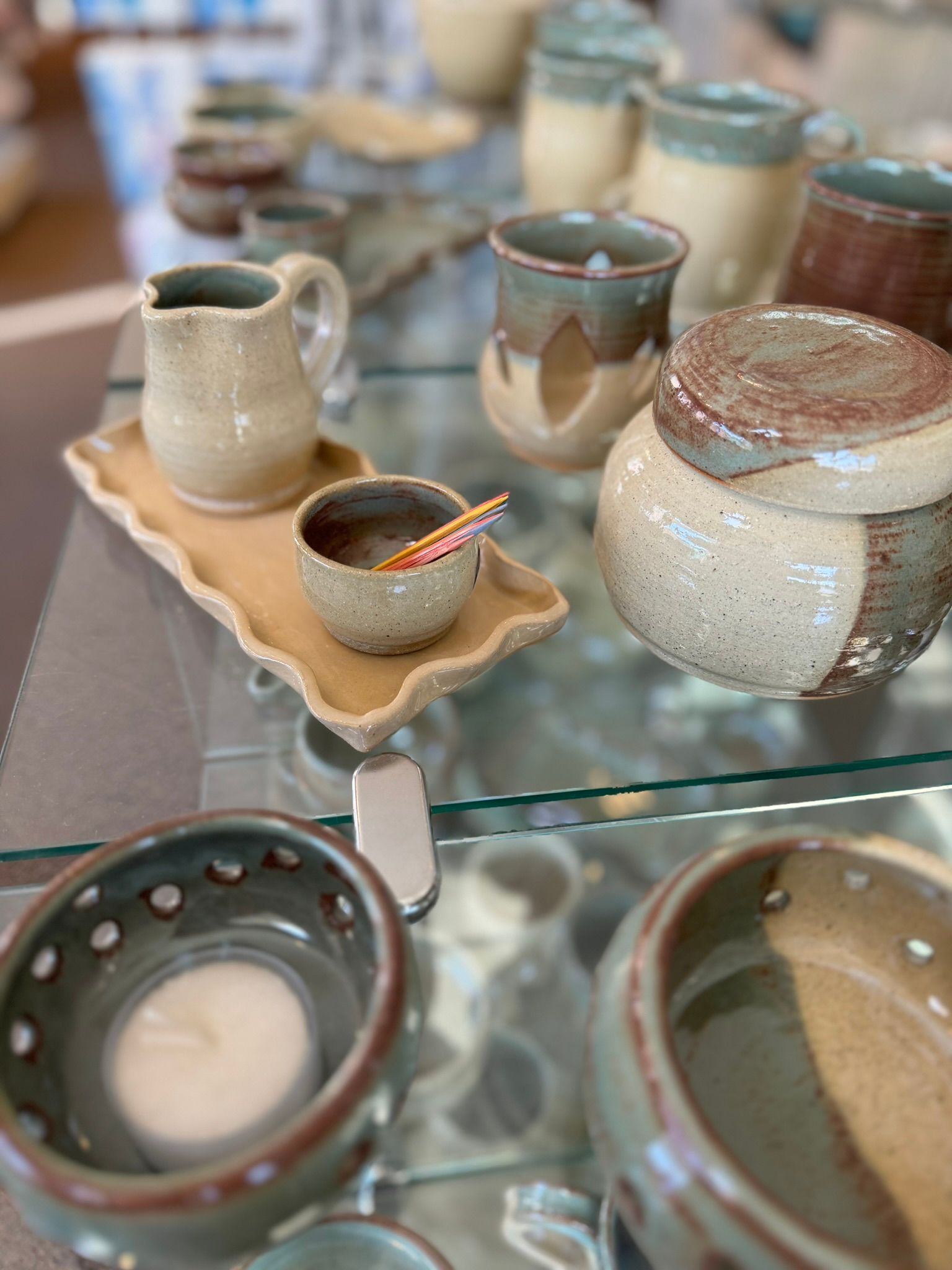 A glass display case filled with a variety of pottery.