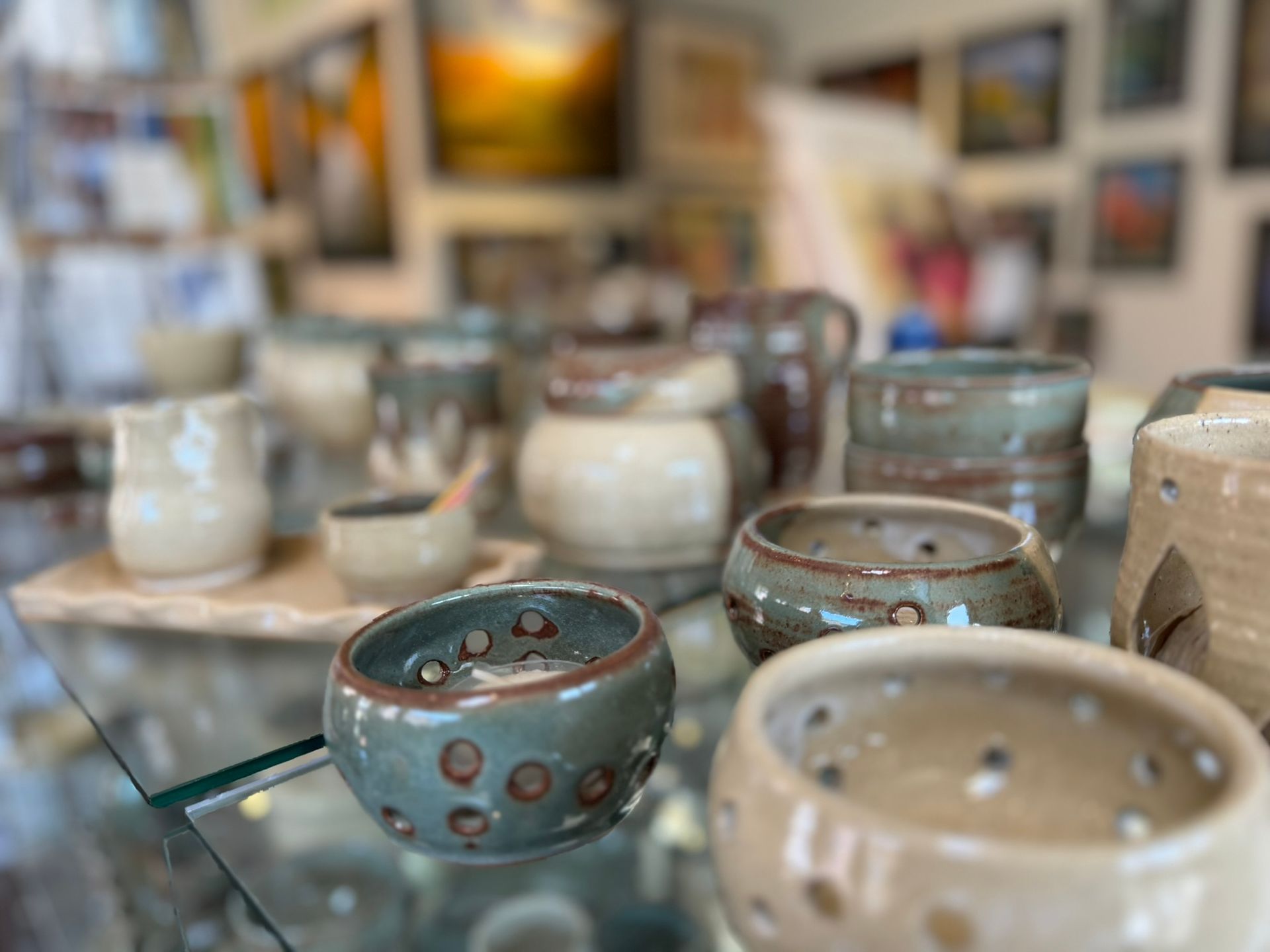 A display of ceramic bowls on a glass table in a store.