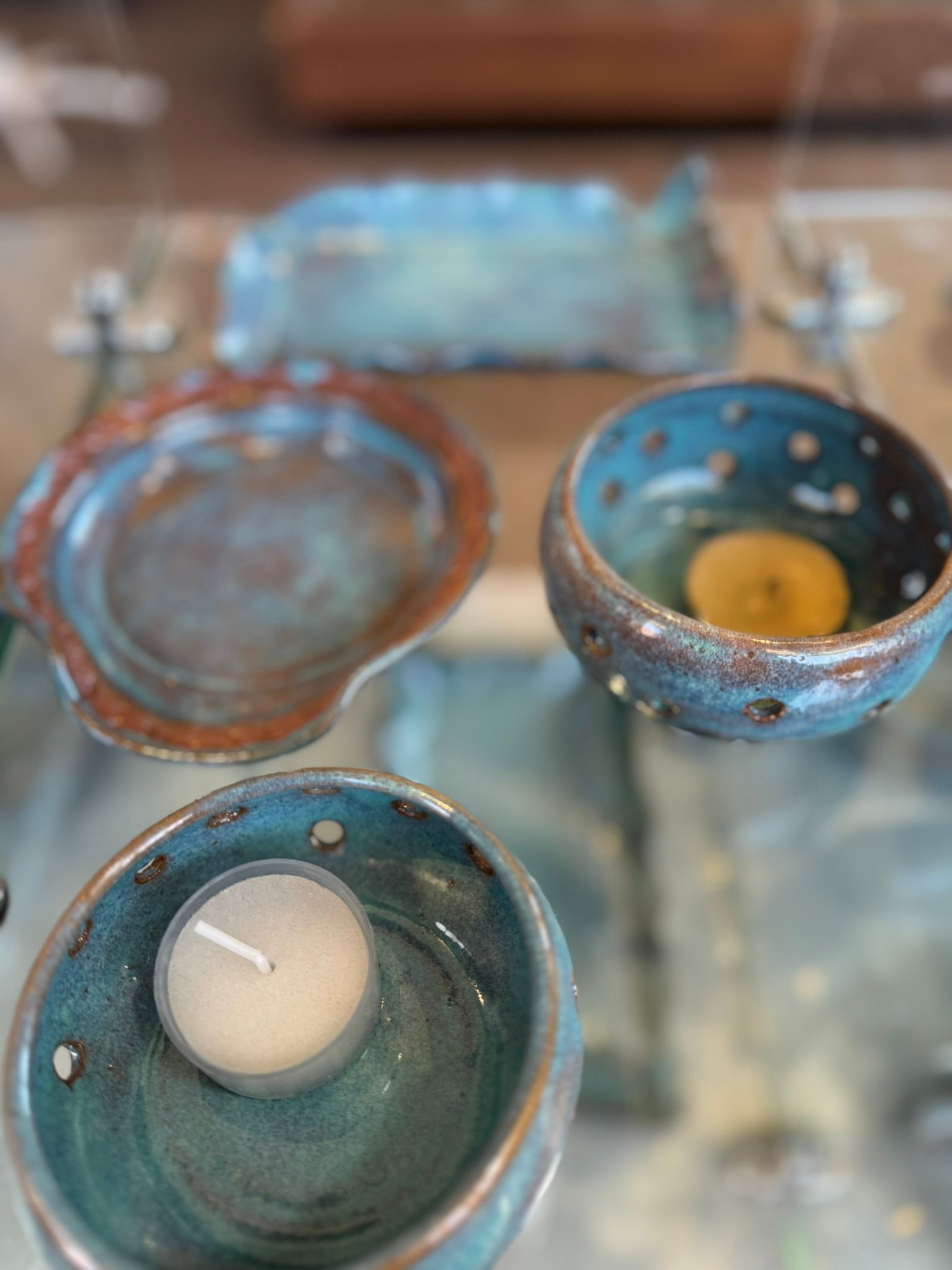 A candle is in a bowl on a table.