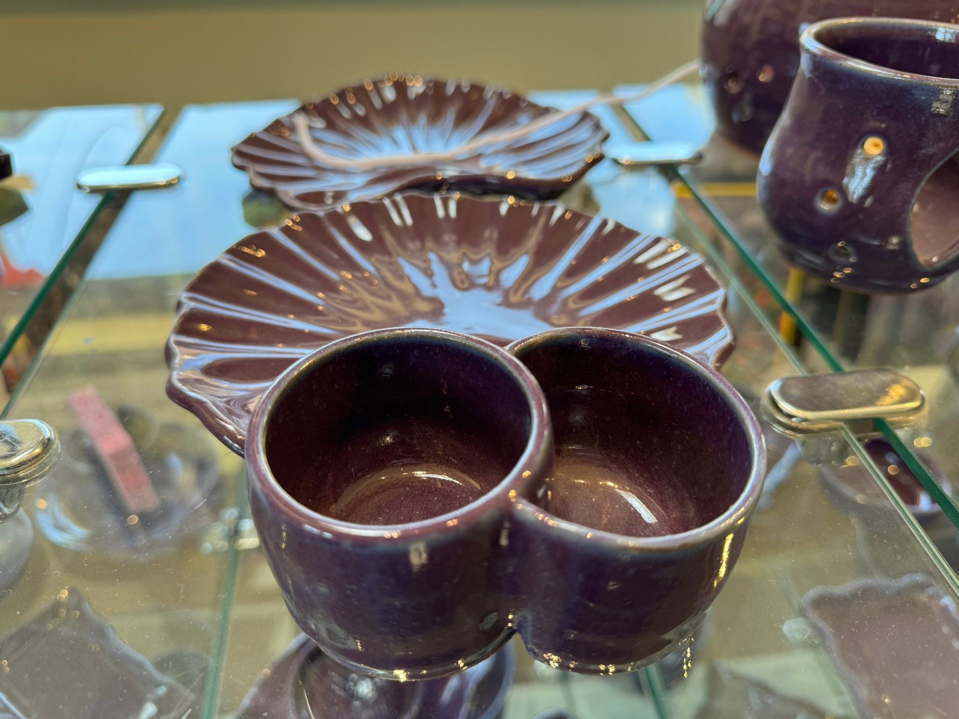 Purple cups and saucers on a glass shelf