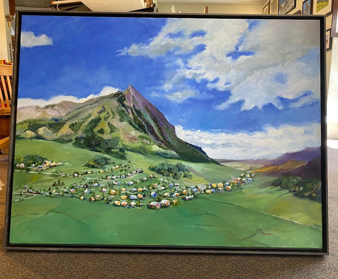 A large painting of a landscape with a mountain in the background is hanging on a wall.