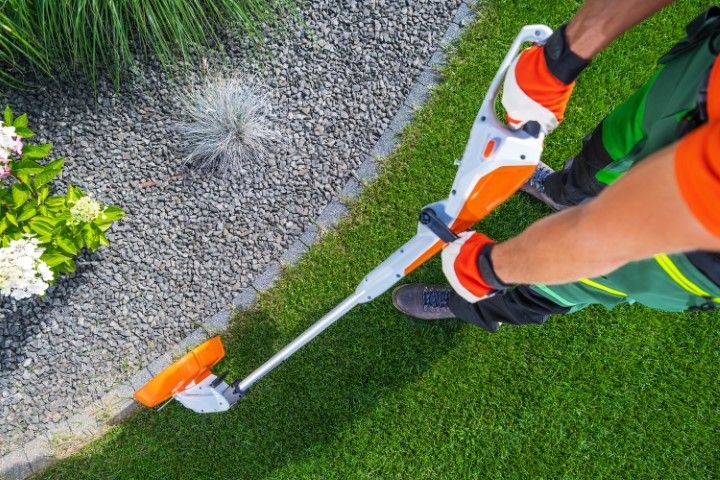 A person is using a lawn mower to cut the grass.