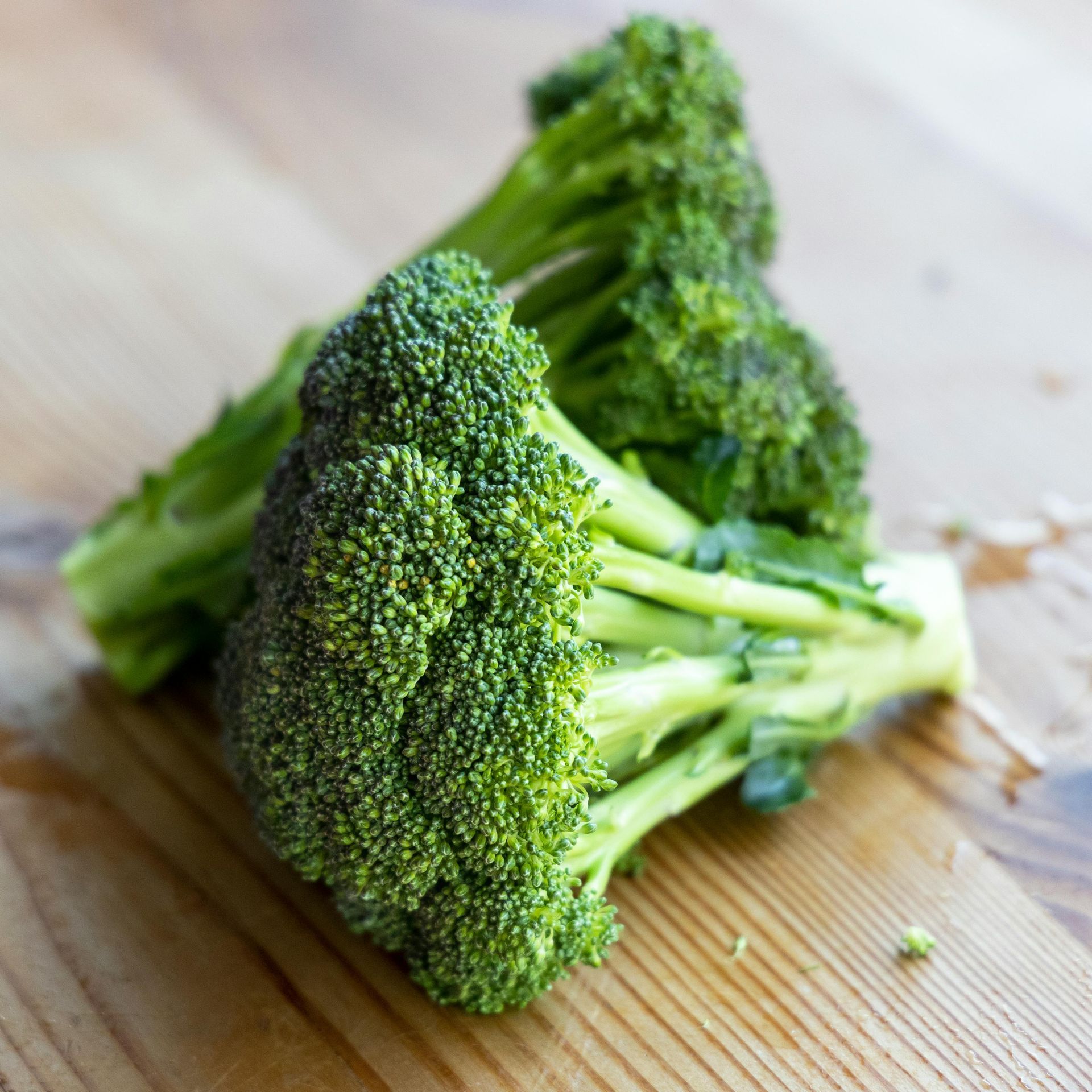 Fresh broccoli florets on a wooden cutting board