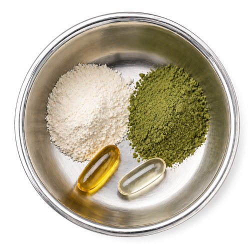 Two supplement capsules beside white and green powder in a metal dog bowl