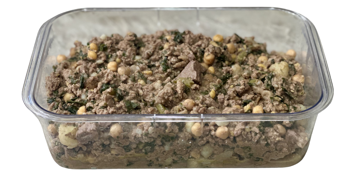 Glass container of cooked homemade dog food with bison vegetables, beef heart and beans.