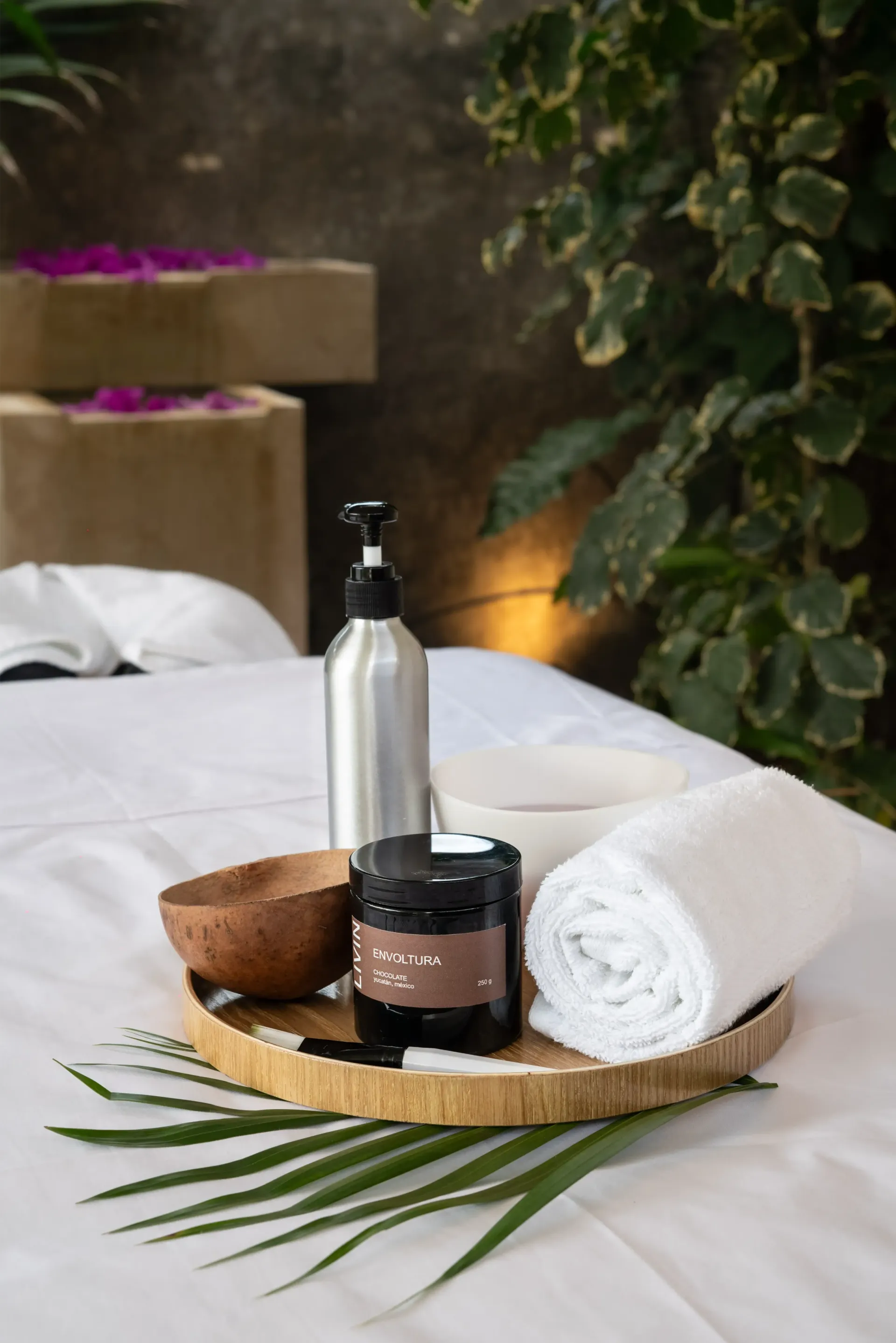 Instalación de terapia de masaje con toallas, aceites y bandeja de madera.