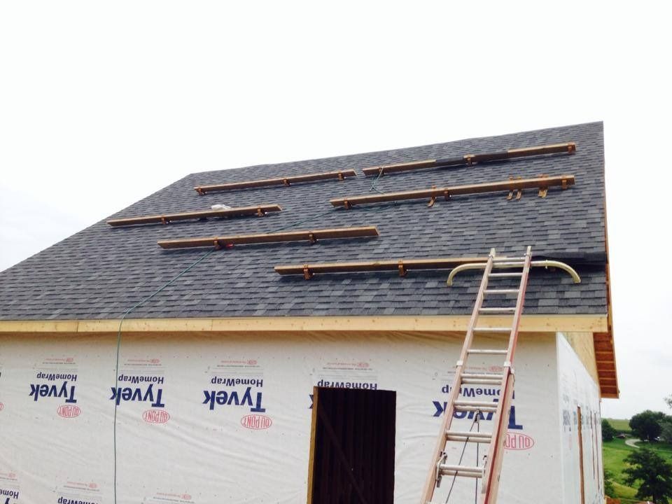 A ladder is attached to the roof of a building that is being built