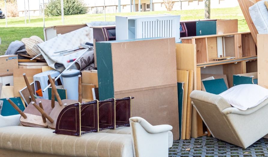 A pile of furniture is sitting on the ground in a living room.
