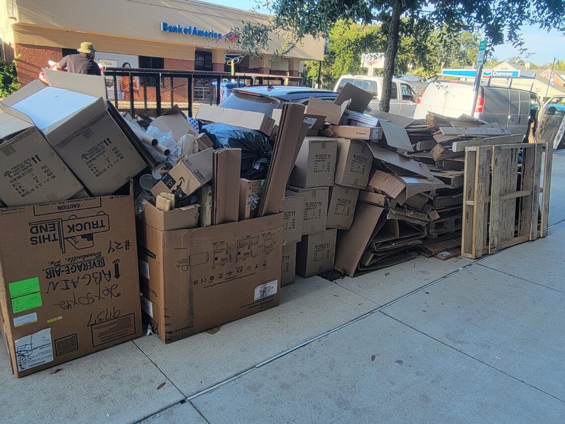 A pile of cardboard boxes and pallets on the sidewalk