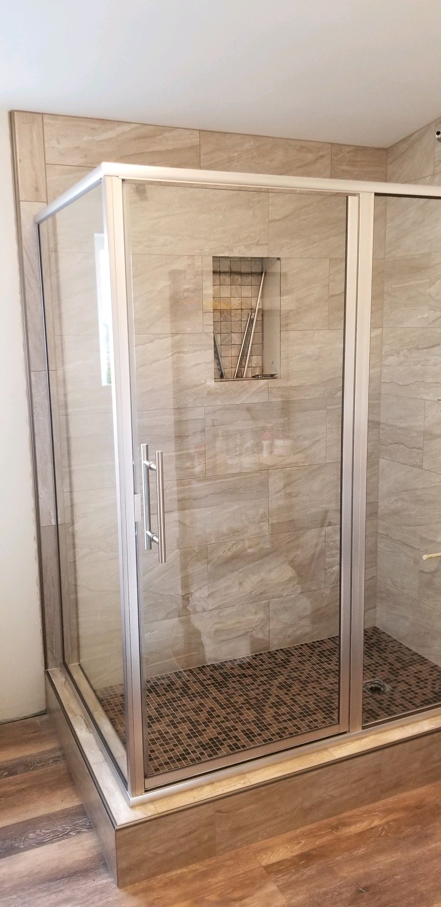 A bathroom with a walk in shower with sliding glass doors.