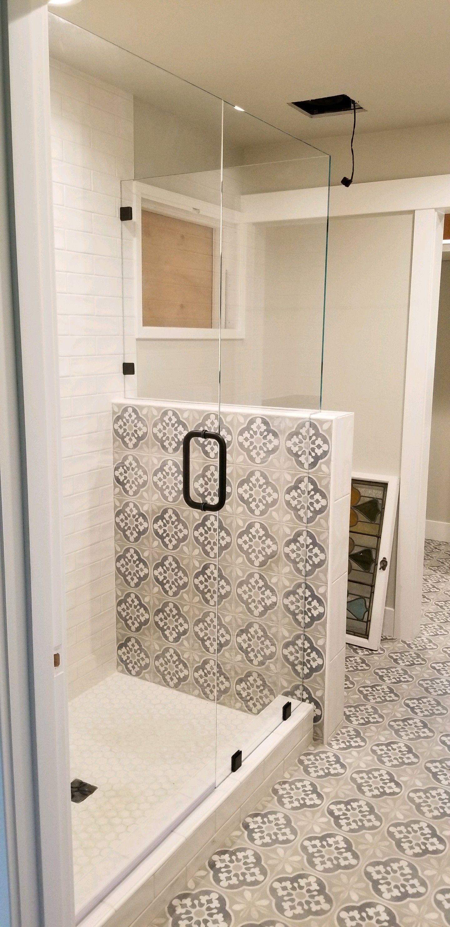 A bathroom with a walk in shower and a tiled floor.