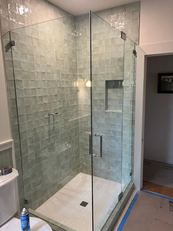 A bathroom with a walk in shower and a toilet.