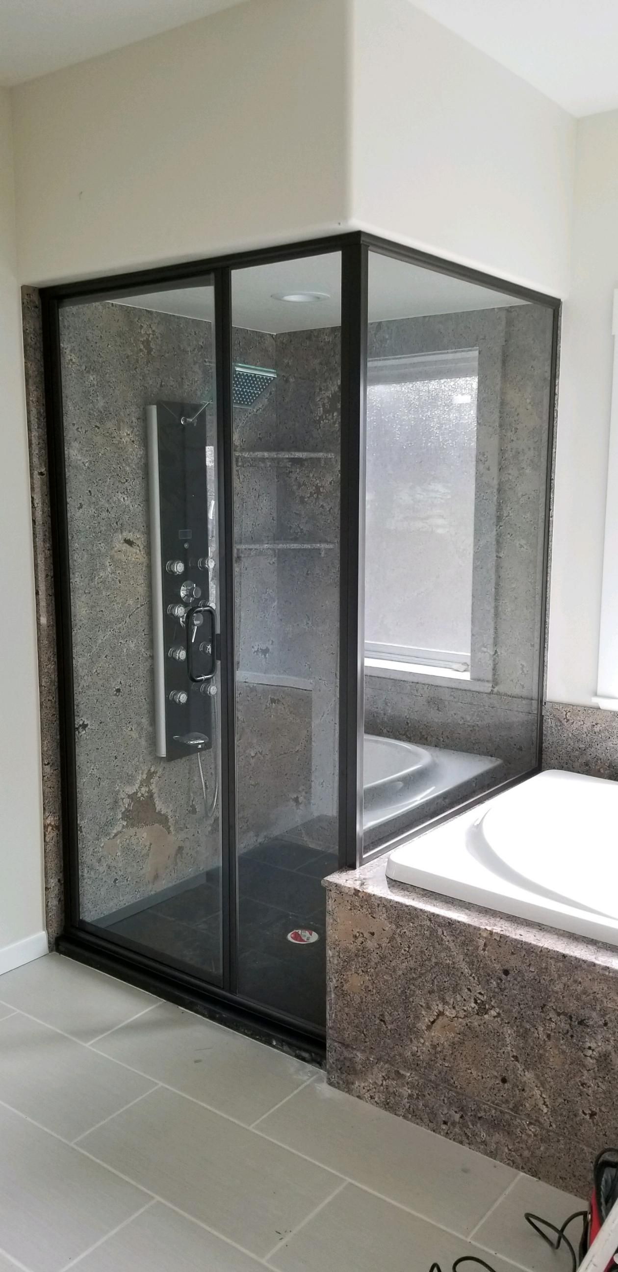 A bathroom with a walk in shower and a bathtub.
