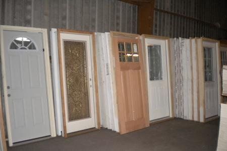 A row of doors are lined up in a warehouse.