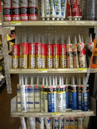 A shelf full of different types of liquid nails