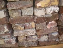A pile of bricks stacked on top of each other on a wooden pallet.