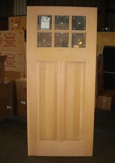 A wooden door is sitting in front of a stack of cardboard boxes that say ' fragile ' on them