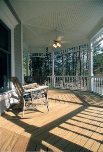 There is a rocking chair on the porch of a house.