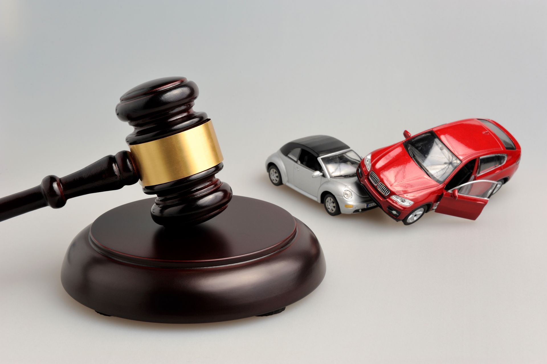Hammer of a judge beside car accident models symbolizing representation by a car accident attorney.