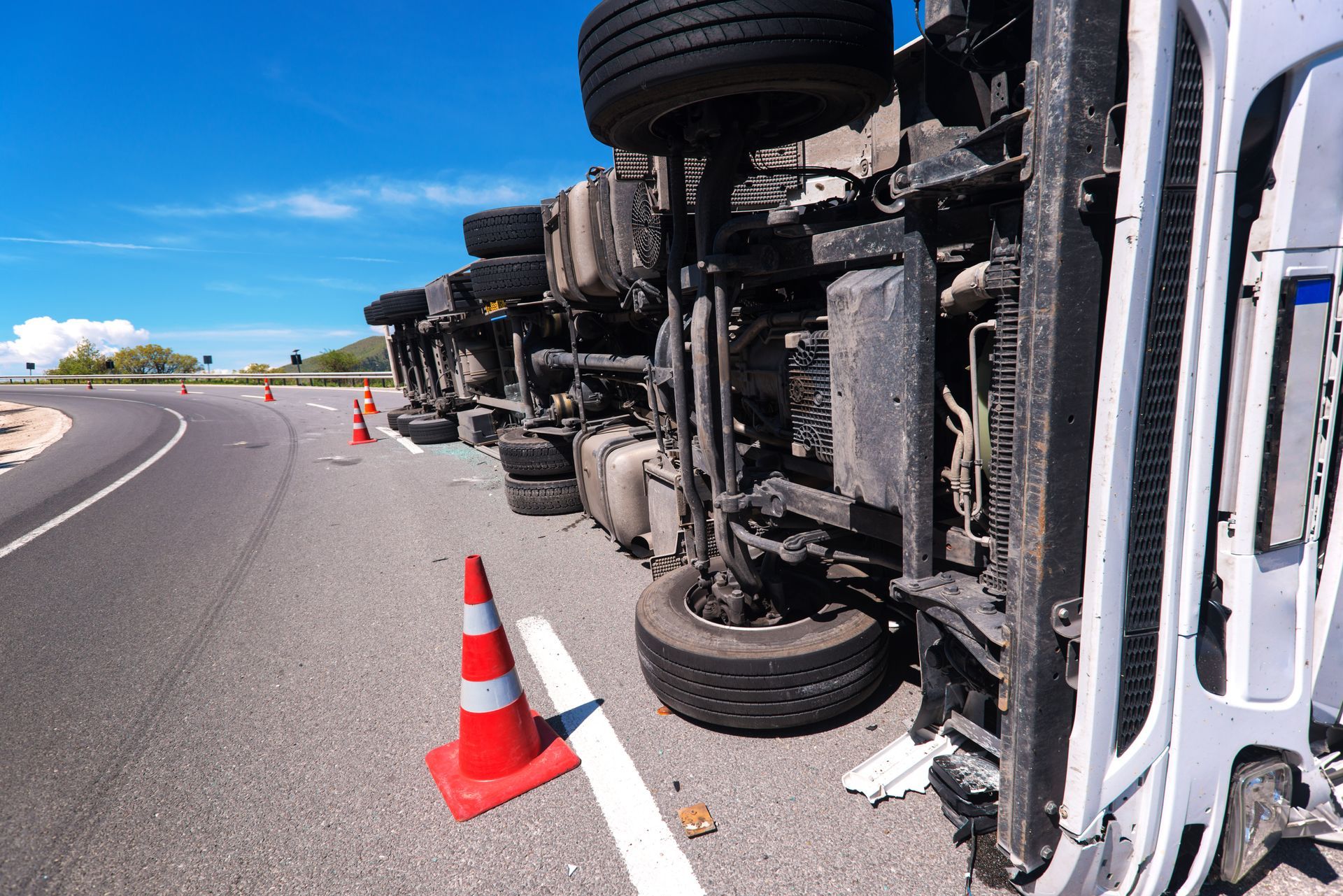 Overturned truck on a highway with traffic cones marking the accident scene. Overturned truck on a highway with traffic cones marking the accident scene.