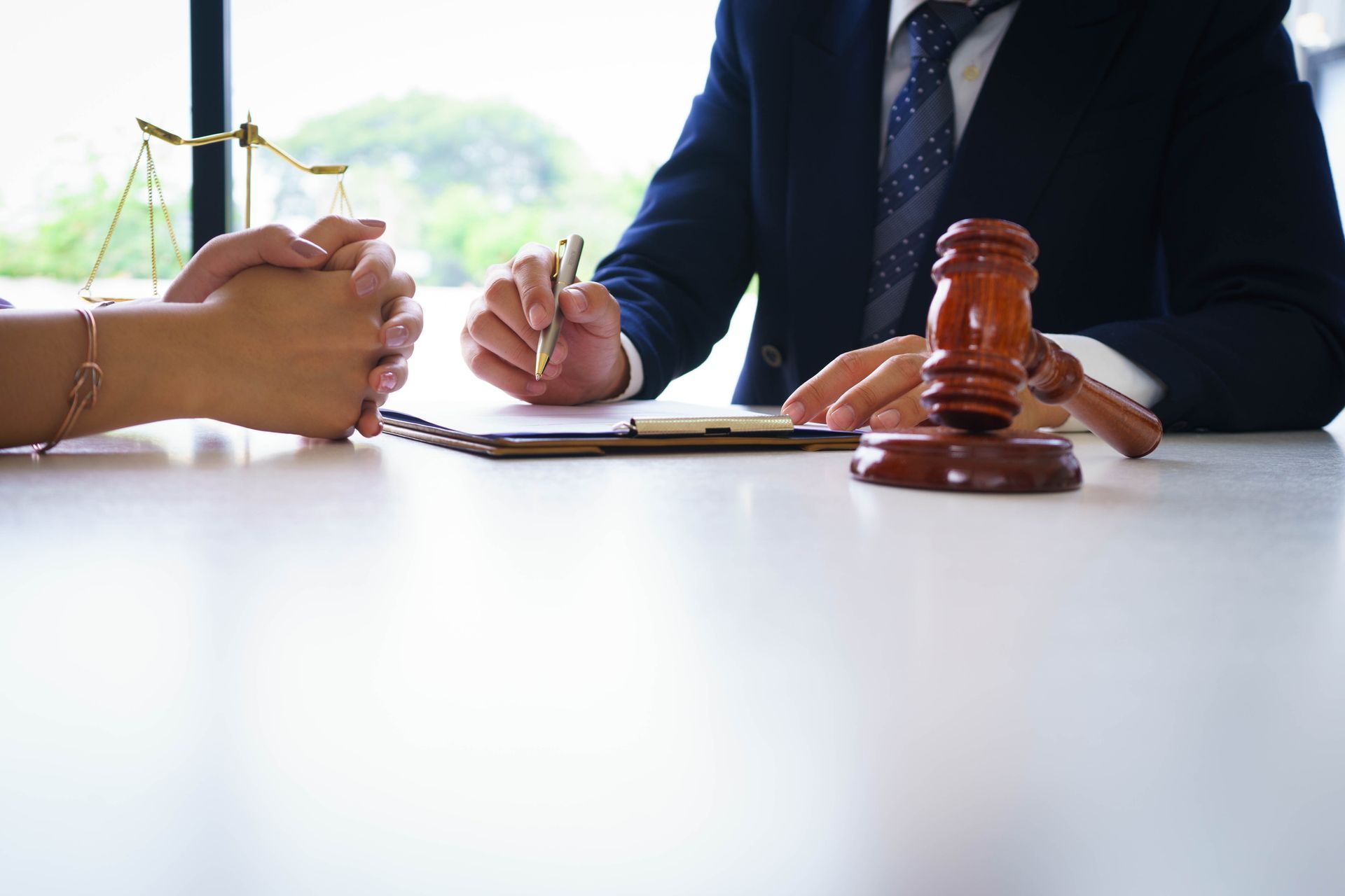 Close-up of personal injury law lawyer consulting client with legal papers and justice gavel. 