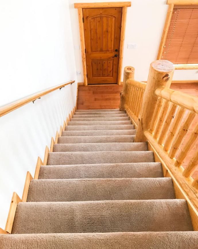 A set of stairs leading up to a wooden door in a house.