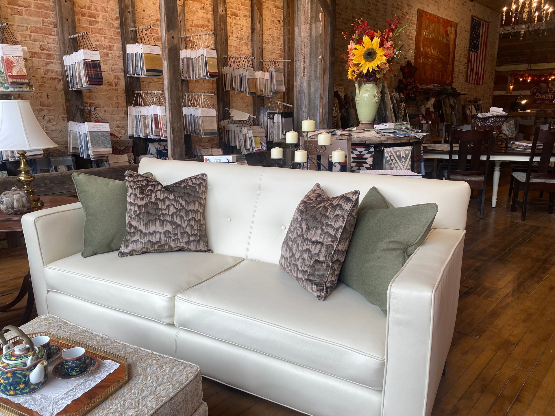 A white couch with green pillows is in a living room.